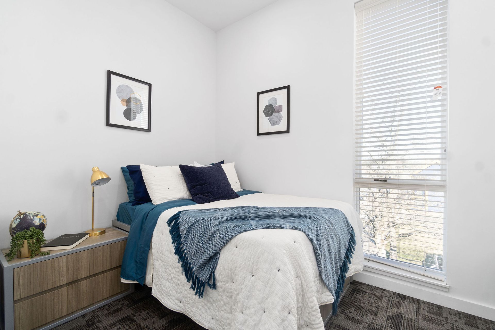 Photo showing a bedroom with a tall window that spans the height of the wall