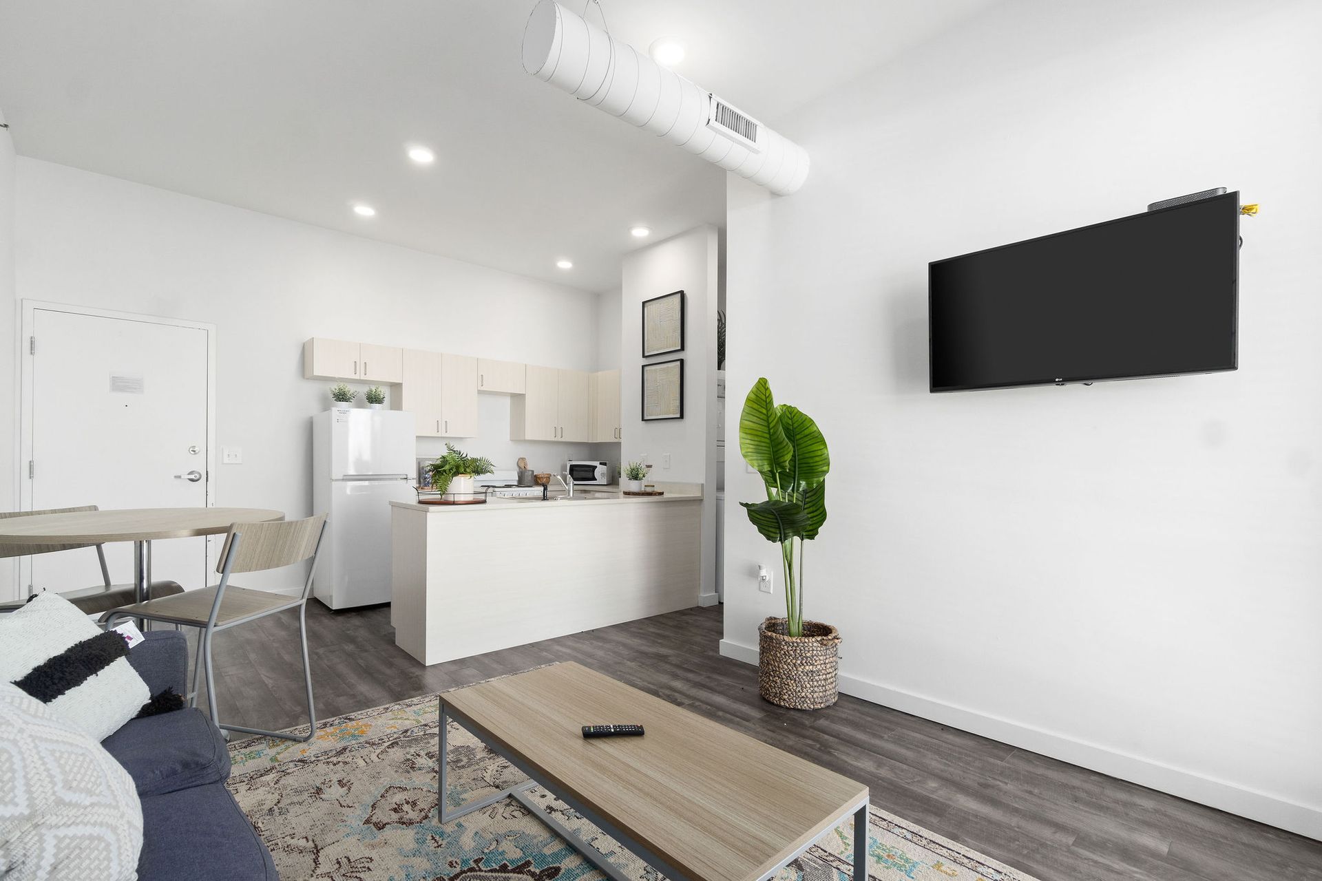 Photo showing a living room with a kitchen in the background