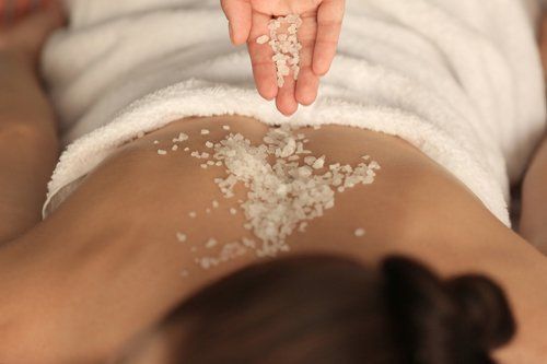 estetista effettua massaggio con sale marino