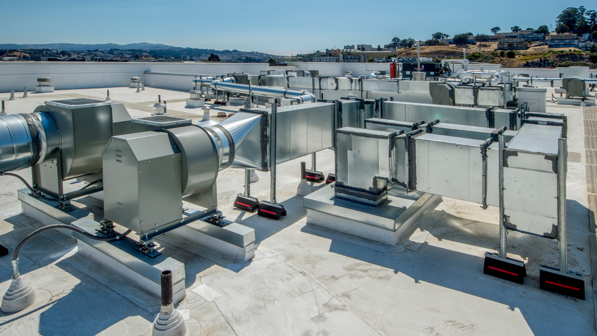 A rooftop with a lot of pipes and fans on it.