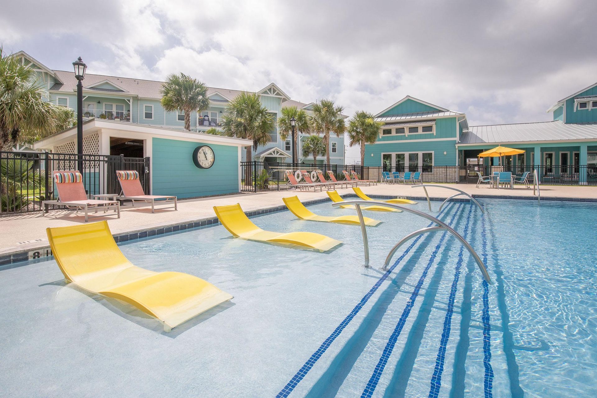 A large swimming pool with yellow lounge chairs at Pearl Point in Rockport, Texas.