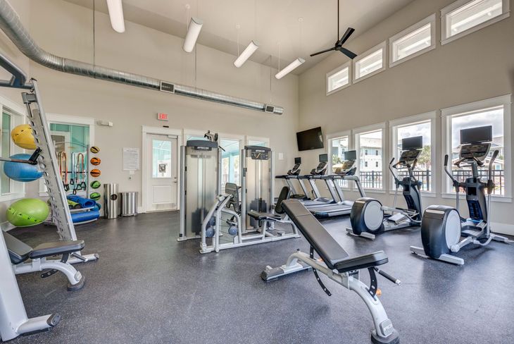 Gym with weight machines, treadmills, and exercise balls.