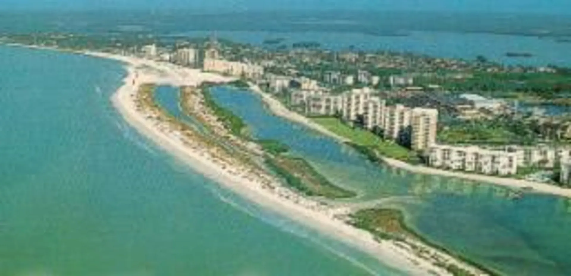 An aerial view of a city on a small island in the middle of the ocean.