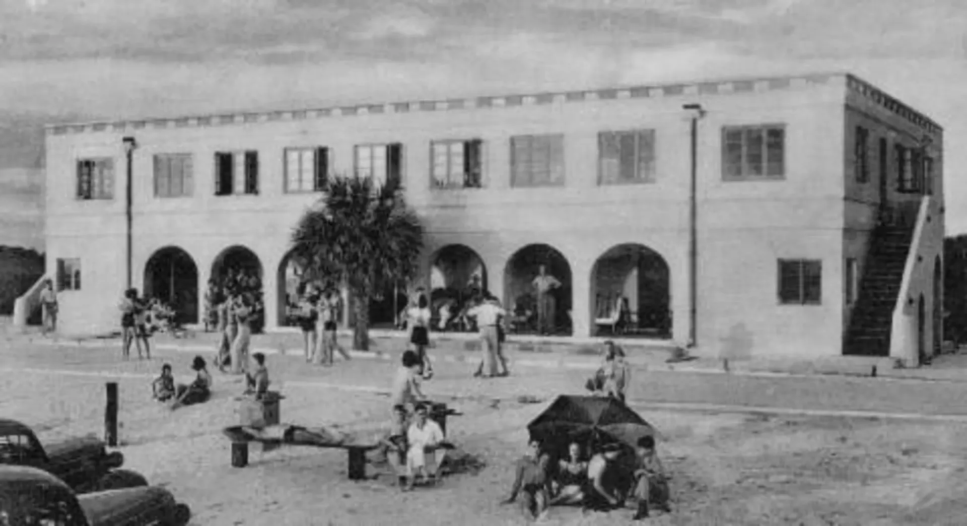 A black and white photo of people in front of a large building