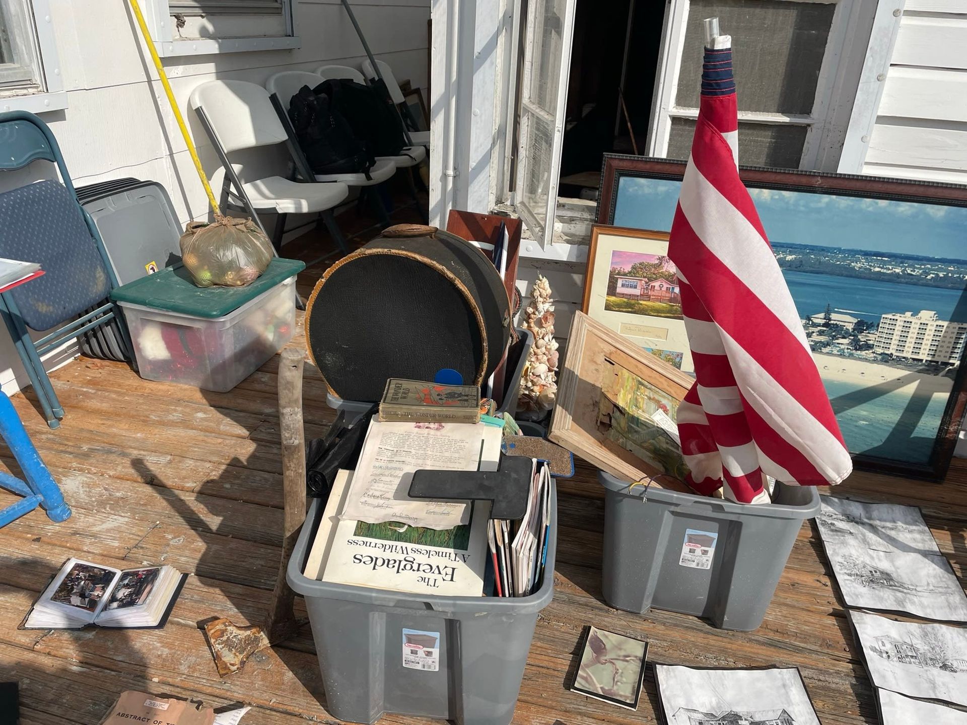 A pile of boxes and a flag on a wooden deck.