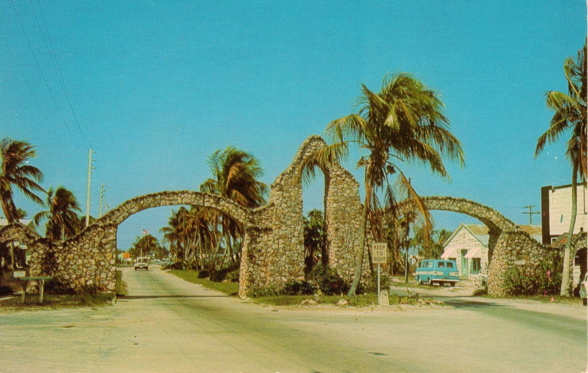 A stone archway with palm trees in the background