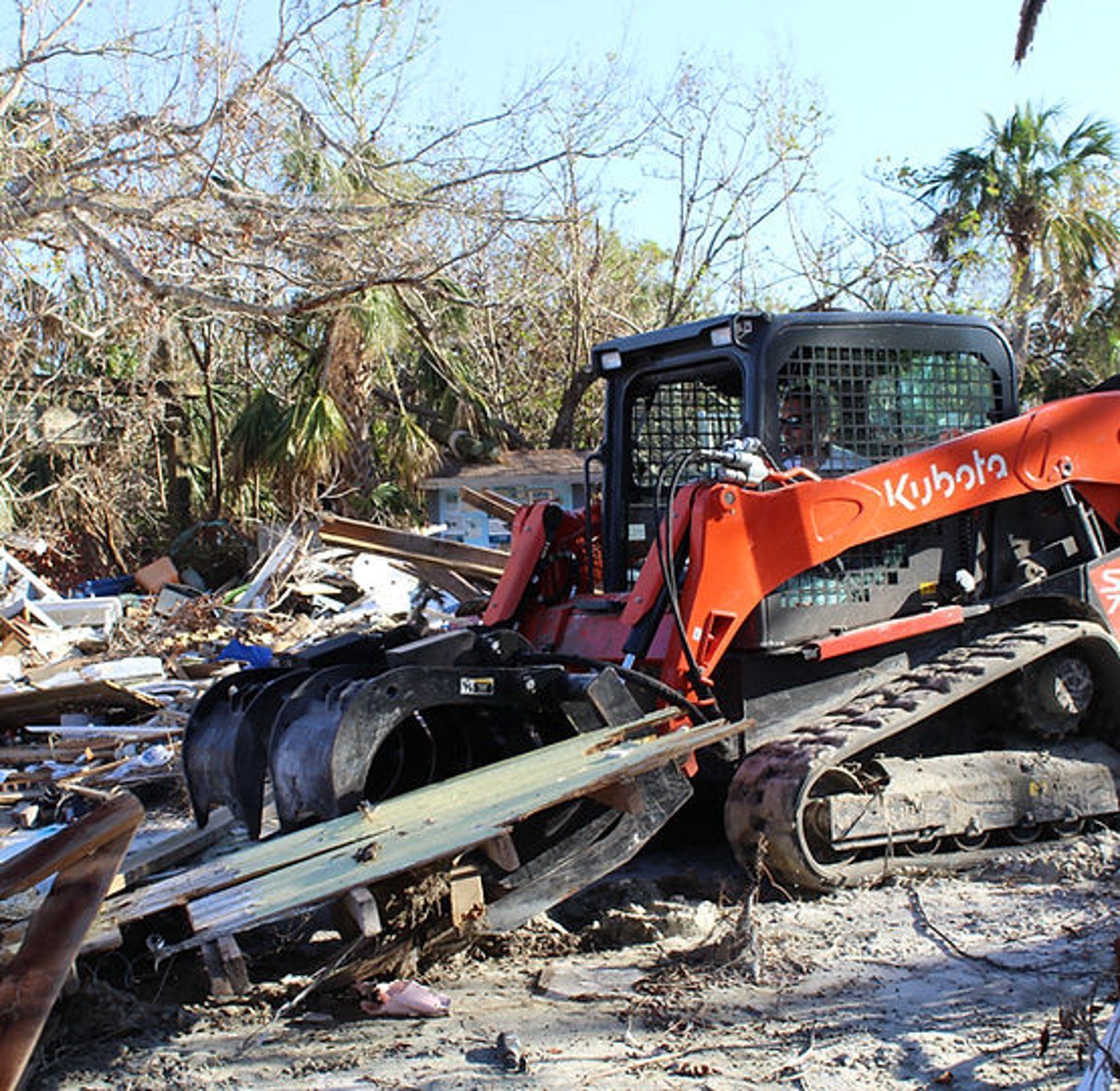 A kubota bulldozer is sitting in a pile of rubble
