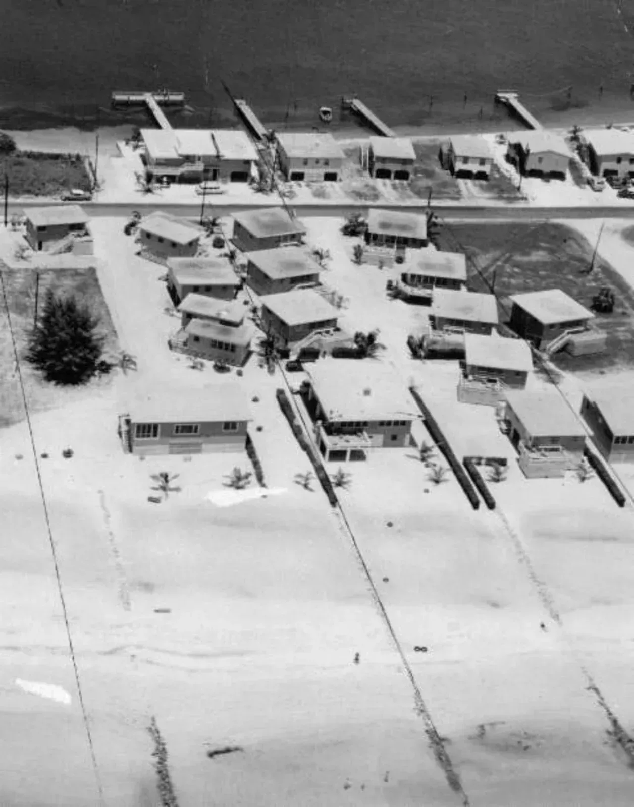 A black and white photo of a residential area covered in snow