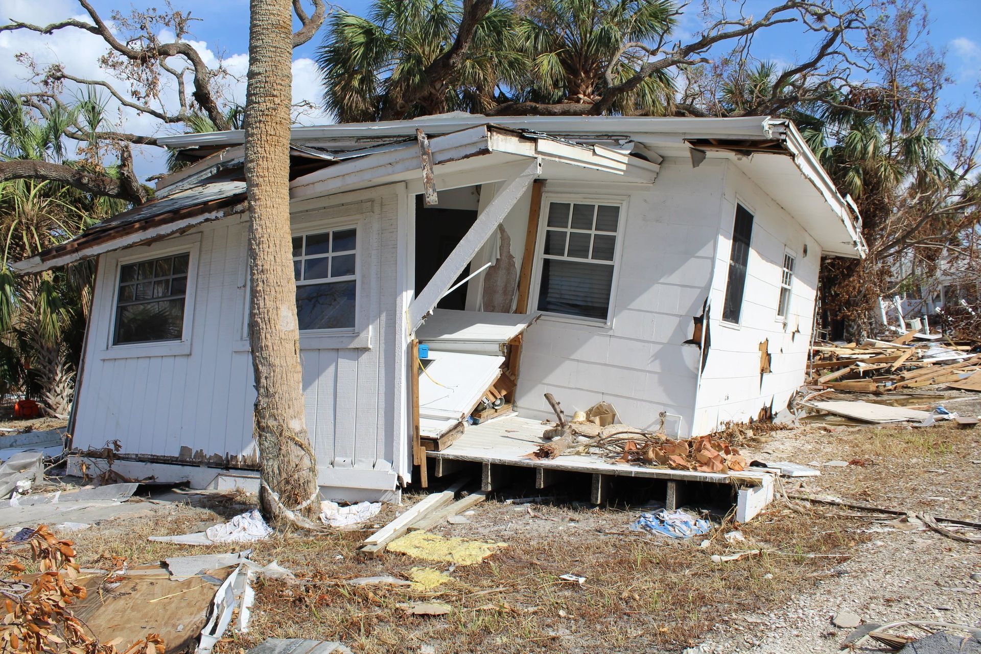 A small white house with a tree in front of it