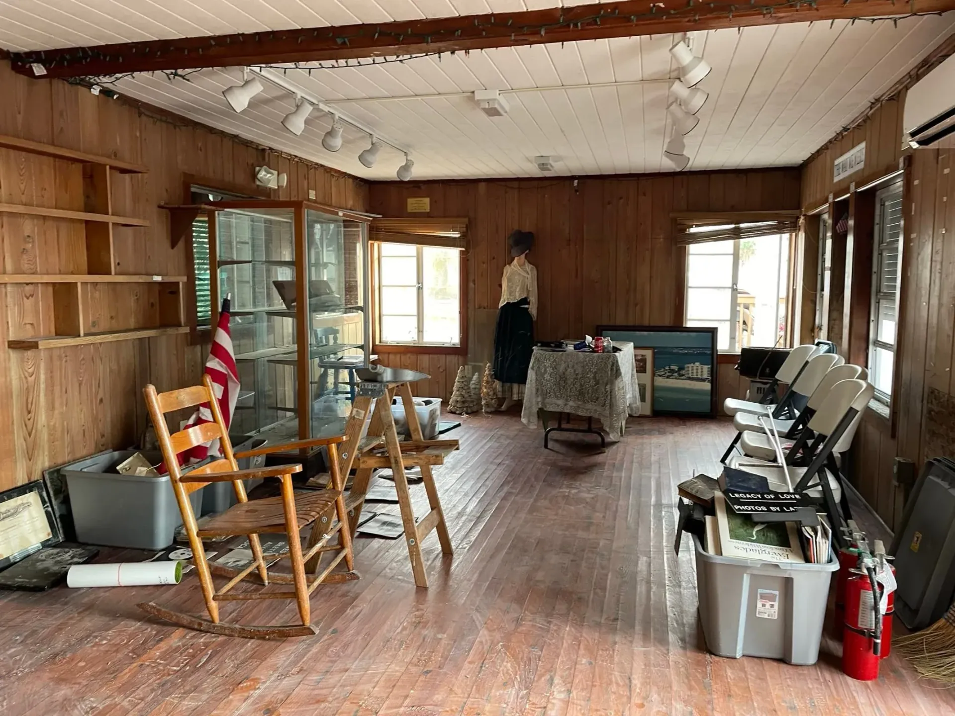 A large room with wooden walls and a rocking chair.