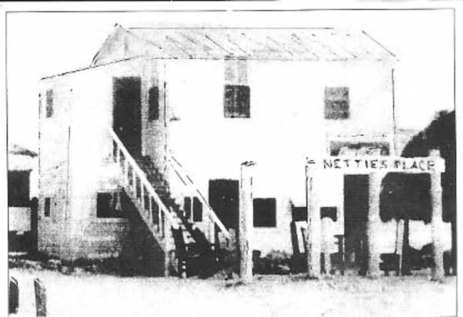 A black and white photo of a building that says nettles place