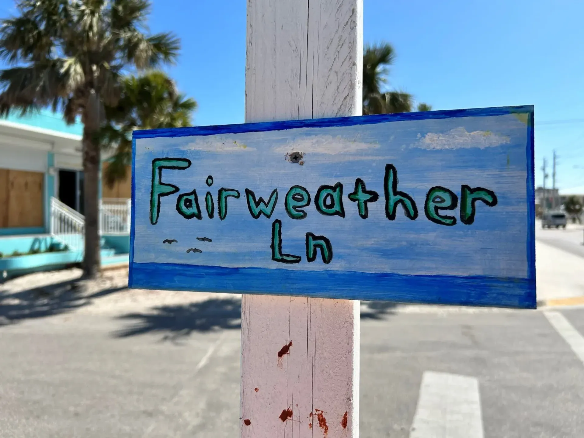 A sign on a pole that says fairweather ln