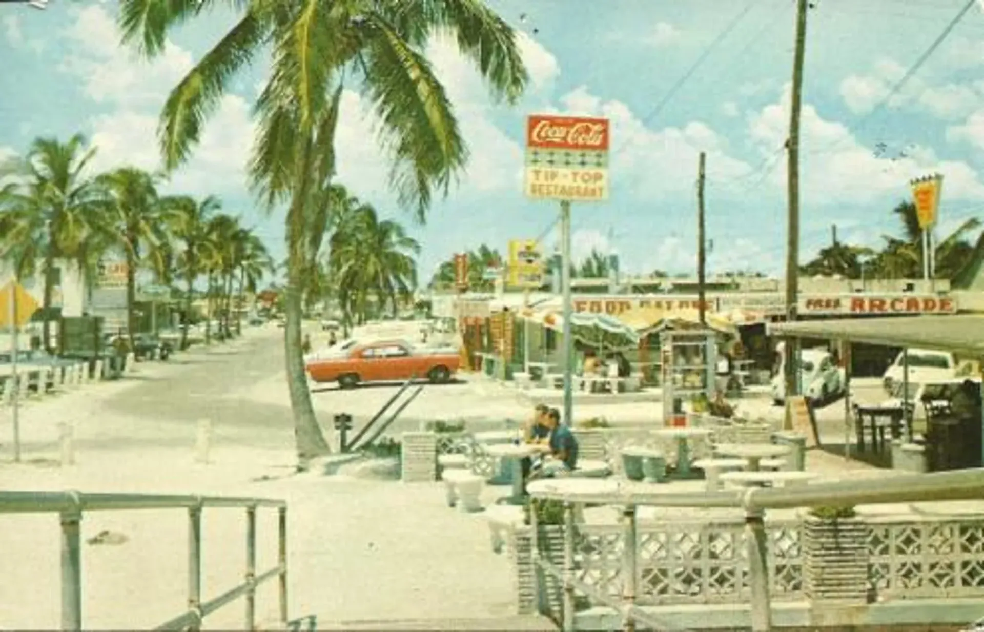 A coca cola sign is on the side of a road