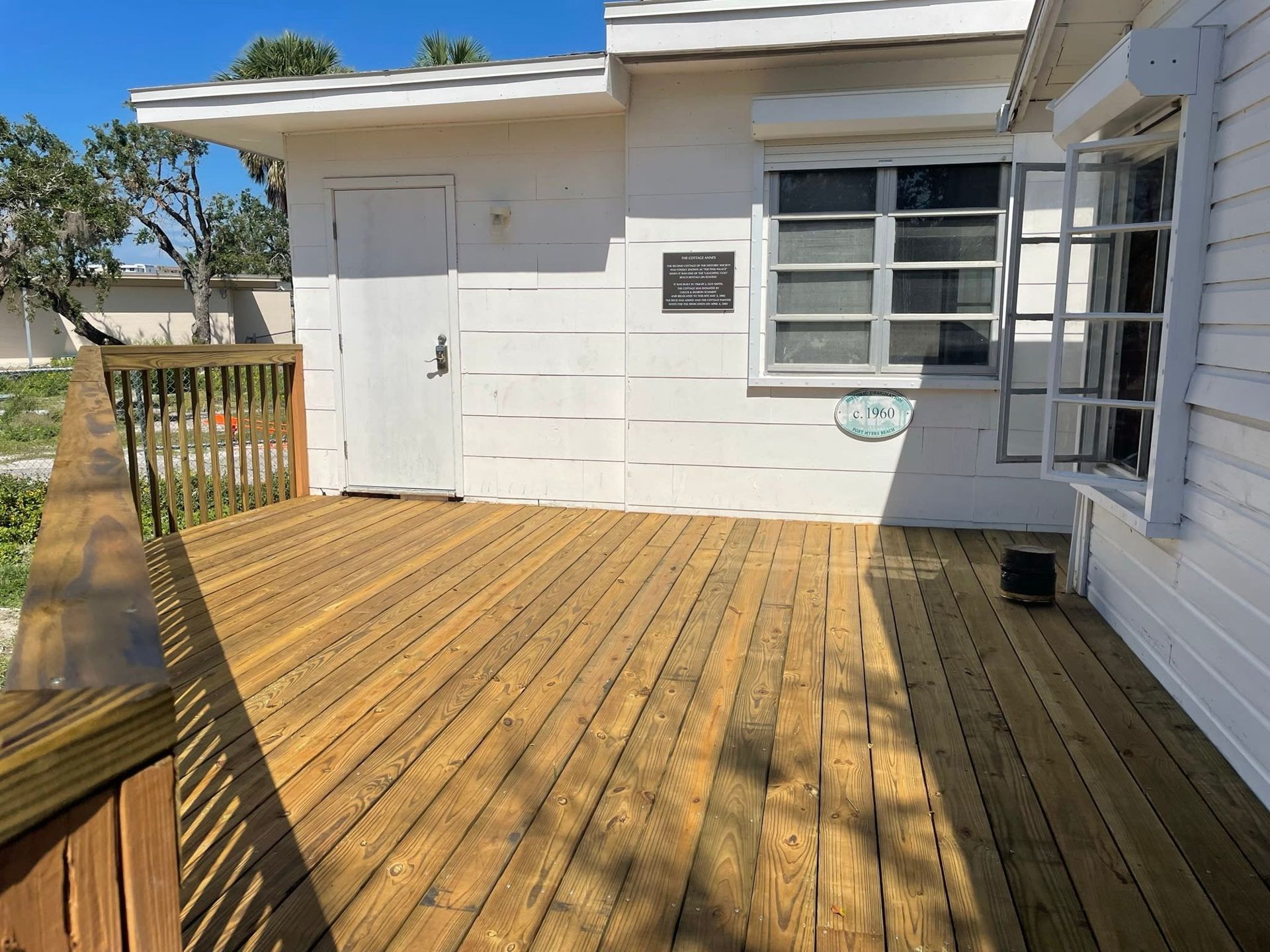 A white house with a wooden deck in front of it