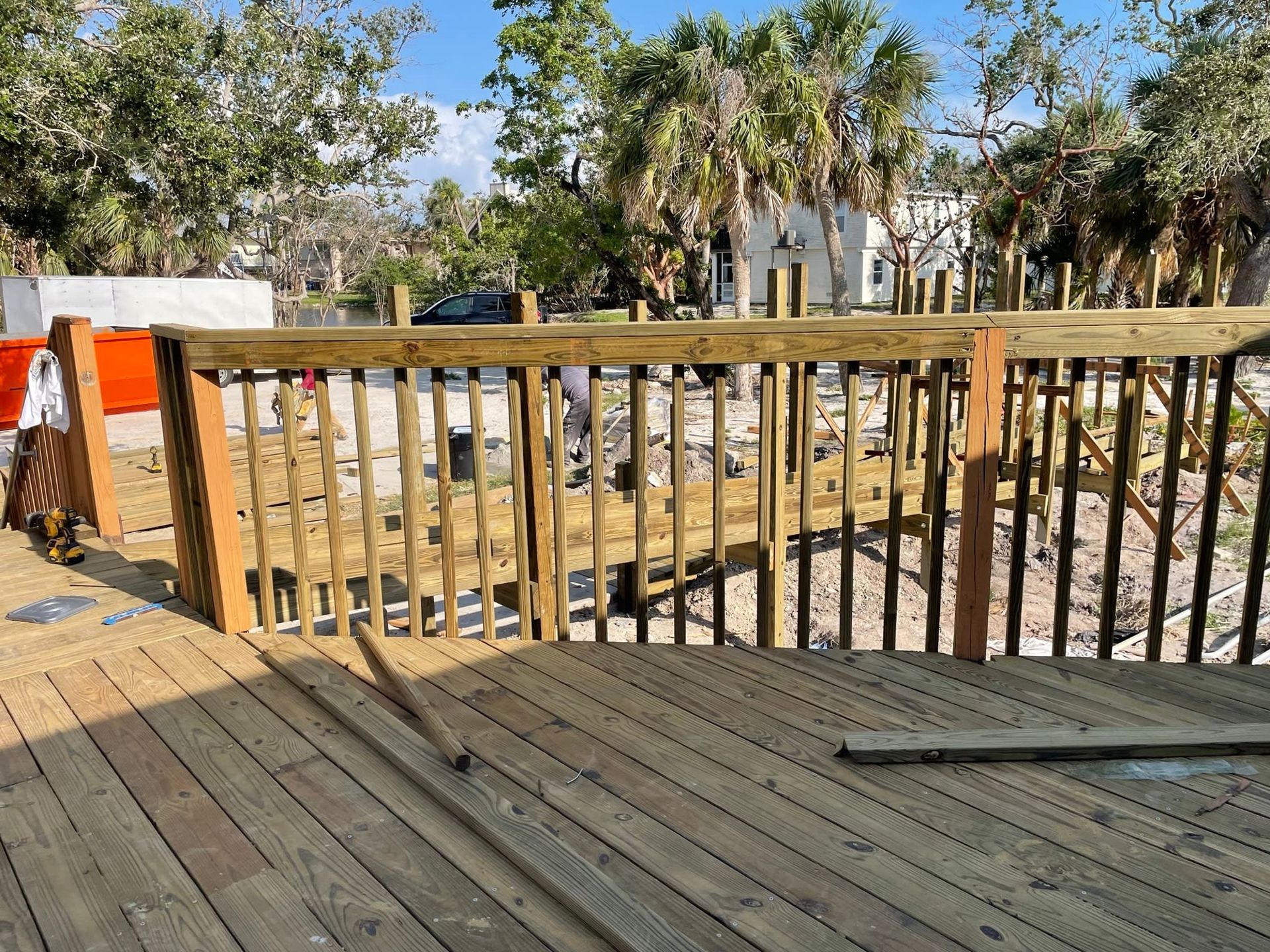 A wooden deck with a wooden railing is being built.