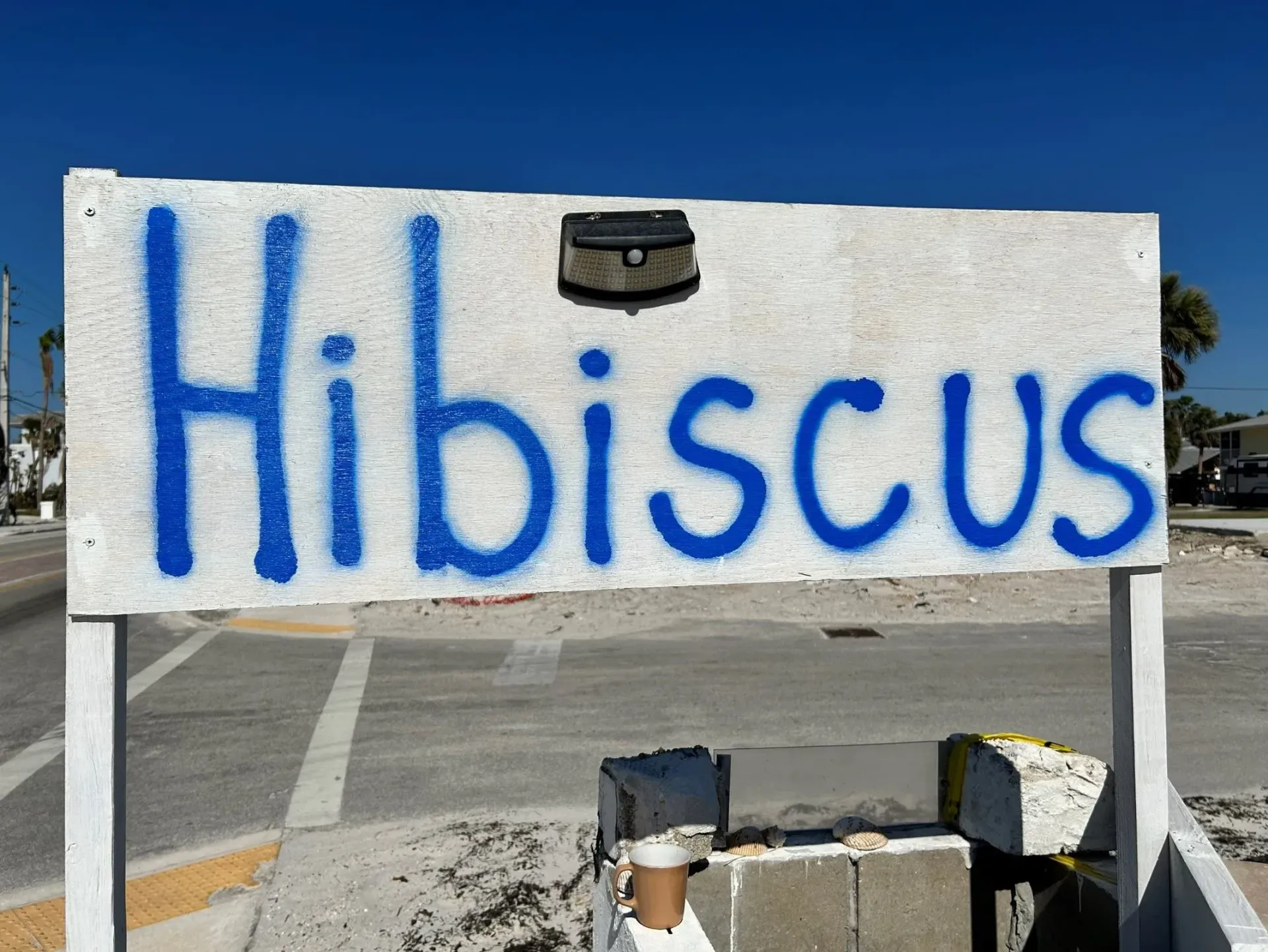 A white and blue sign that says hibiscus on it