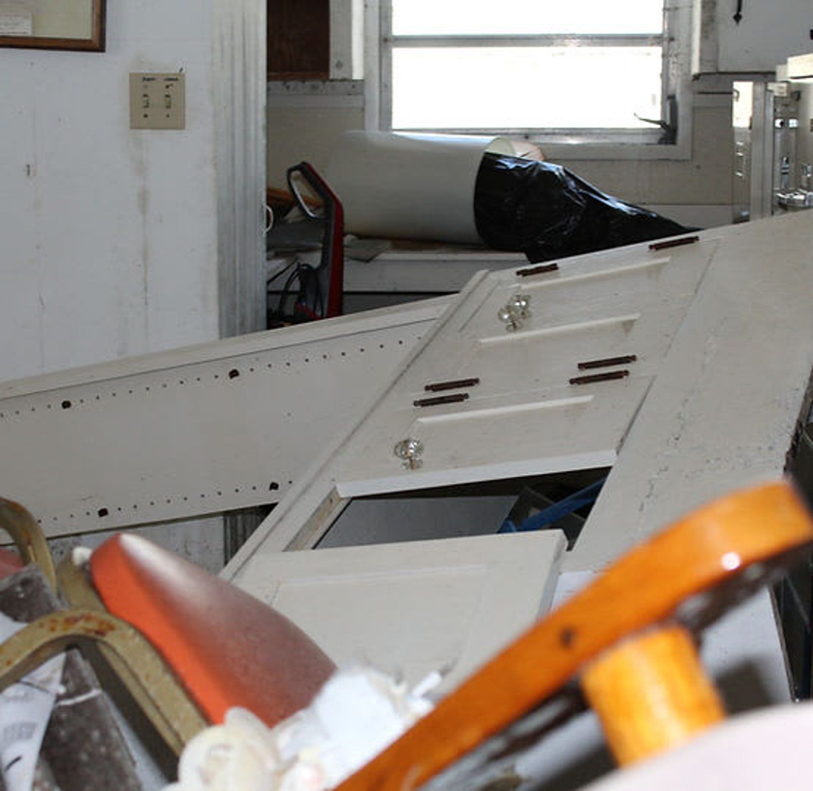 A messy room with a light switch that says ' n ' on it