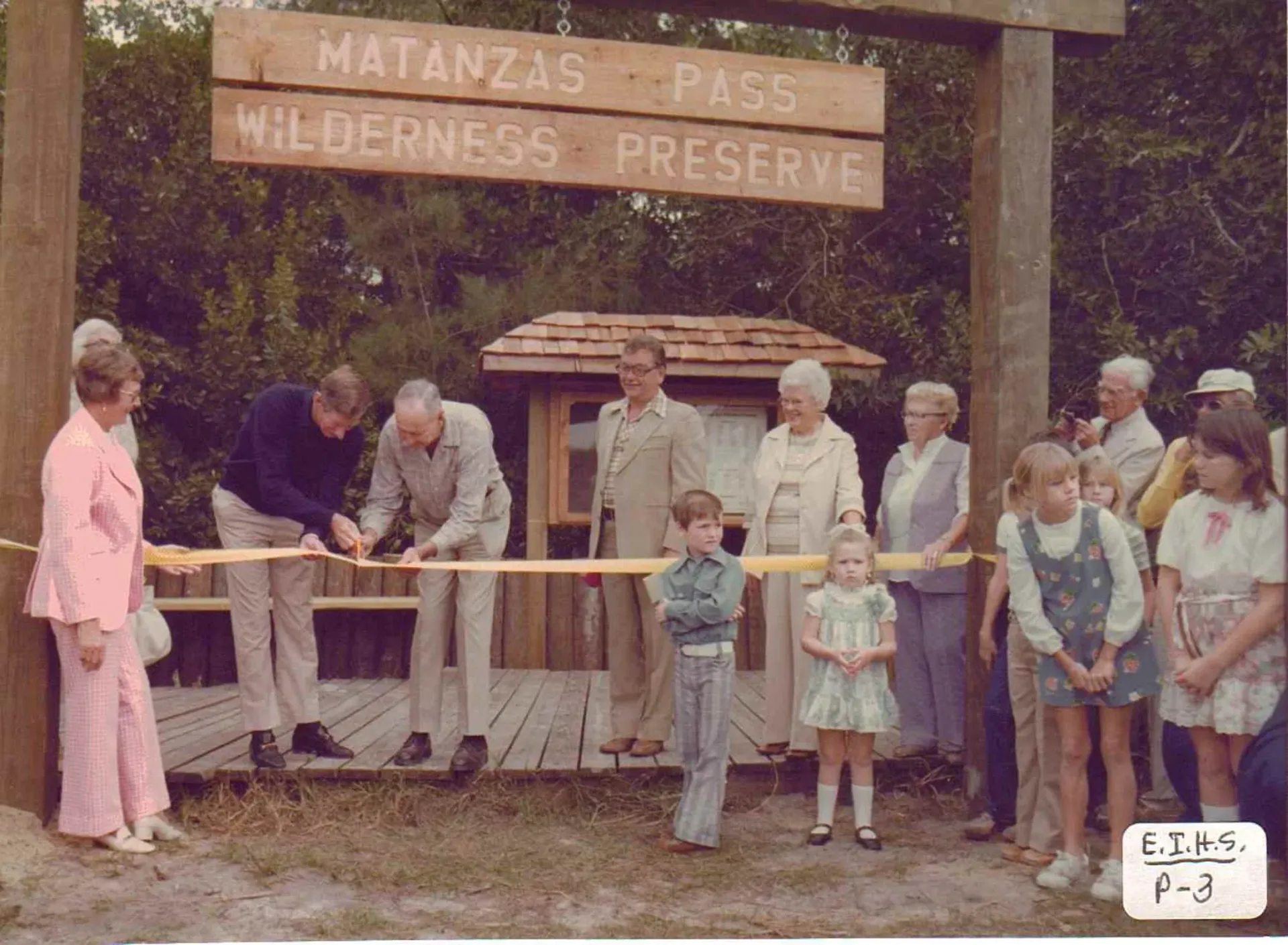 A group of people cutting a ribbon in front of a sign that says matanzas pass wilderness preserve