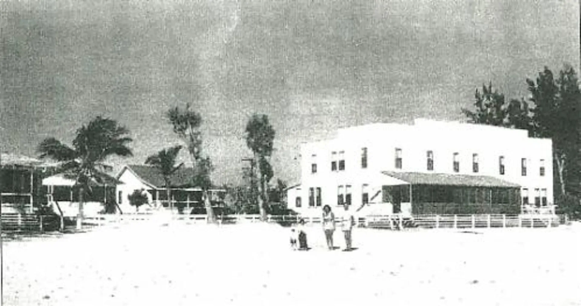 A black and white photo of a building on a beach
