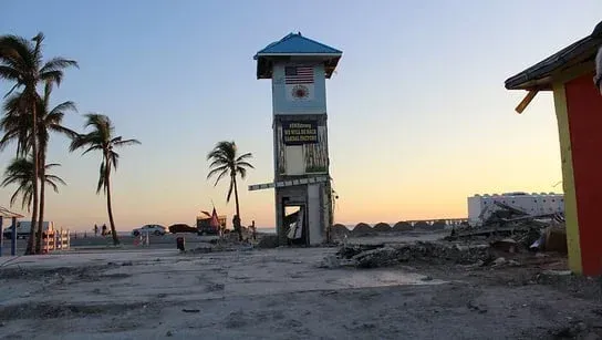 A lifeguard tower on a beach with palm trees in the background
