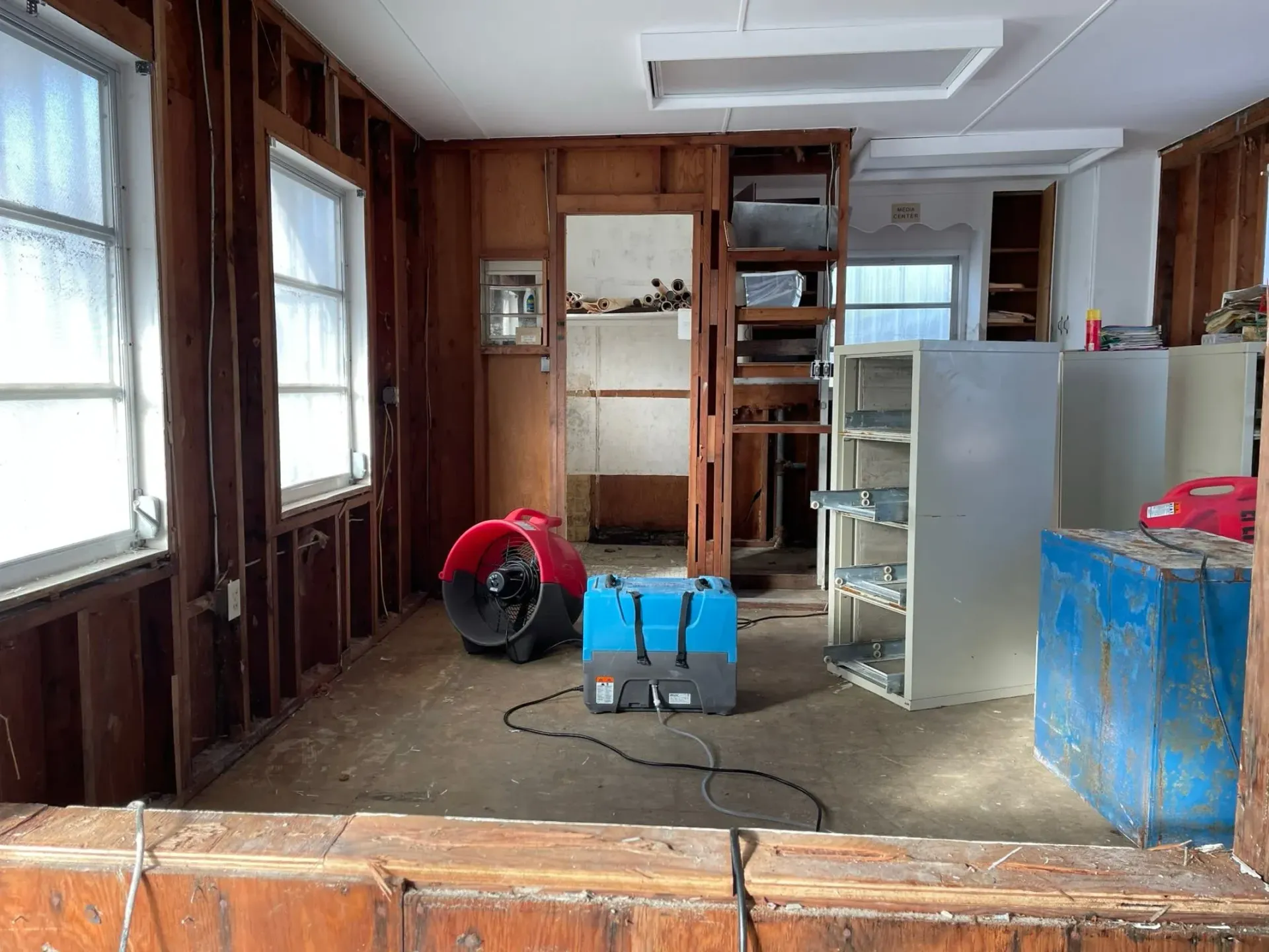 A room with a lot of furniture and a fan in it.