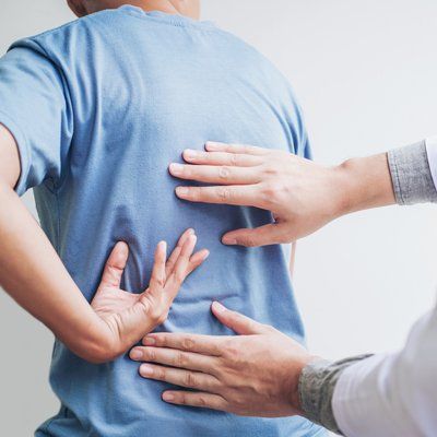 Mid Back Pain — Man And Therapist Holding in His Back In Cotuit, MA