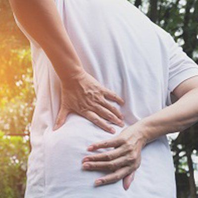 Lower Back Pain — Man Holding on His Lower Back In Cotuit, MA