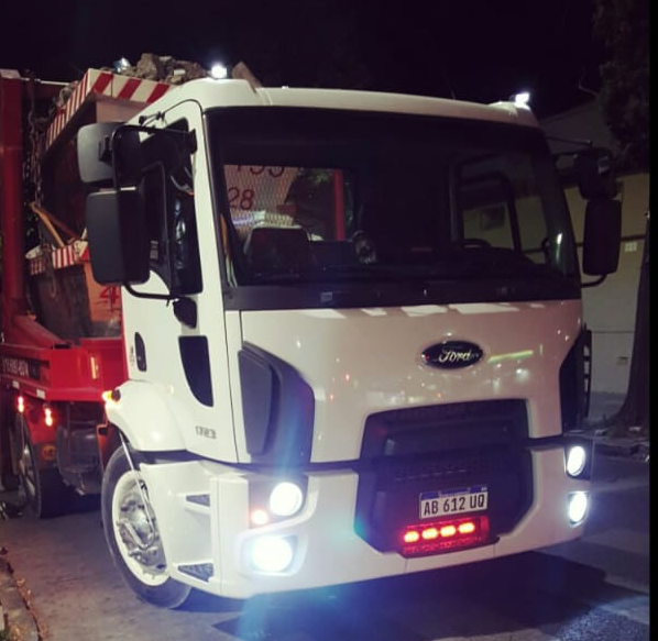 Una camioneta Ford blanca está estacionada en la oscuridad.