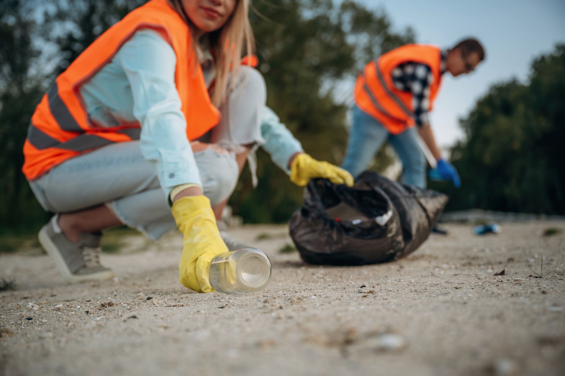 Litter removal service collecting waste outdoors with safety gear
