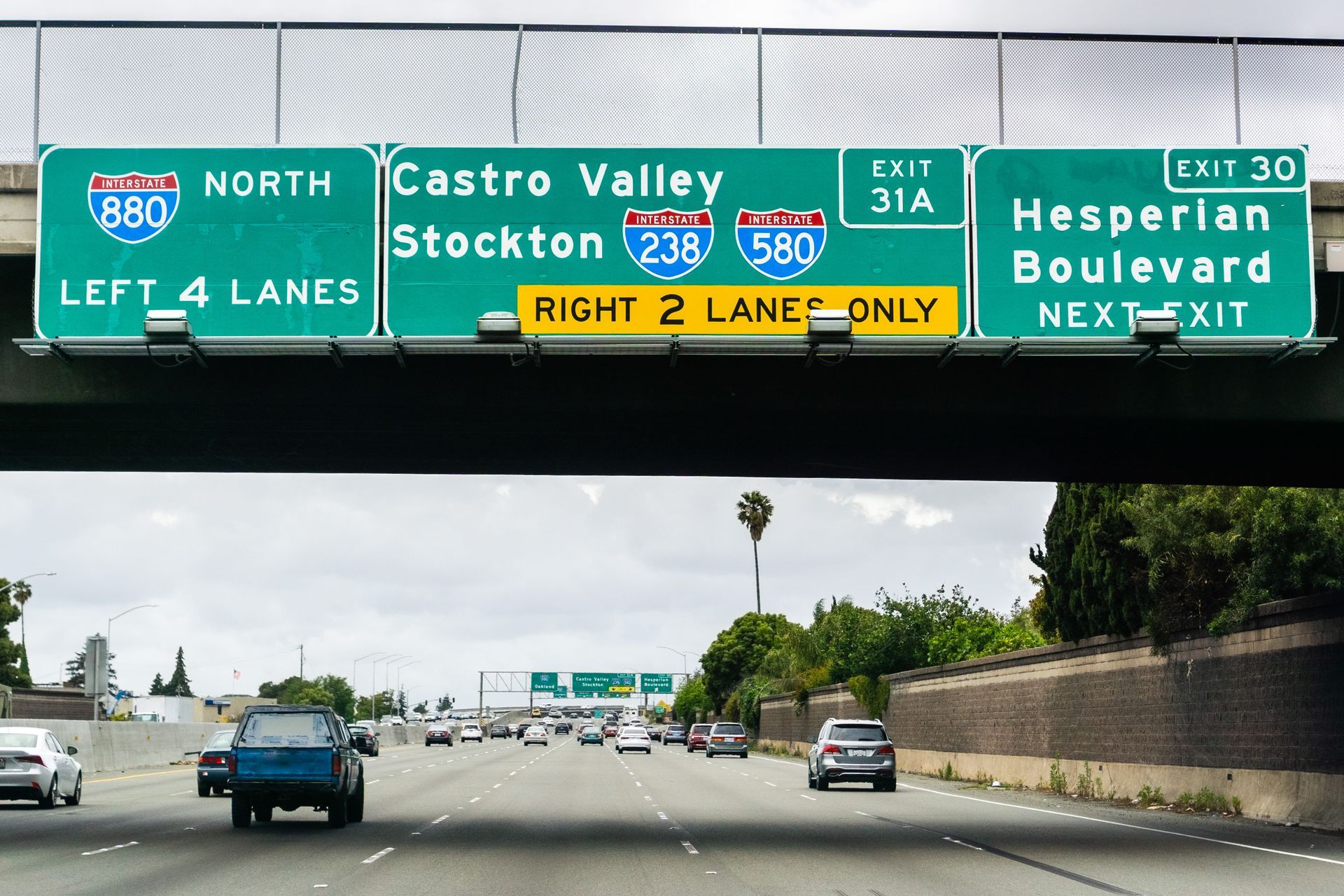 Highway overhead sign installation showing directional traffic signage on freeway