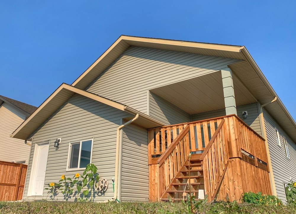 A small house with a wooden deck and stairs.