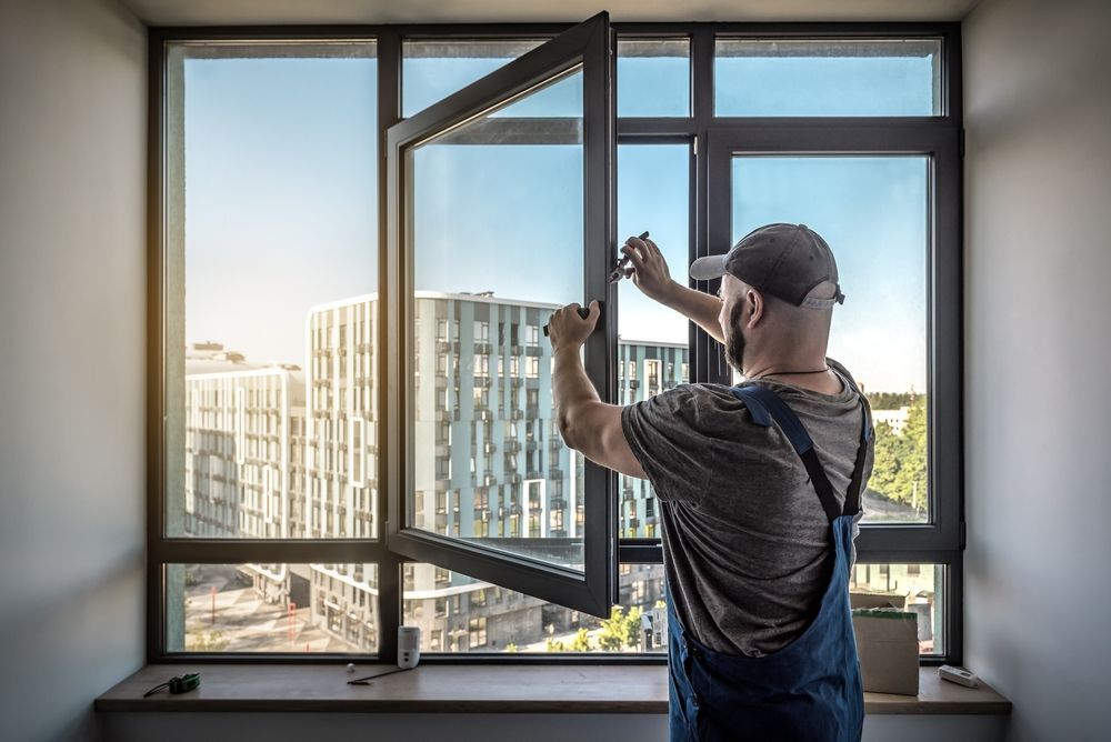 A man is installing a window in a room.