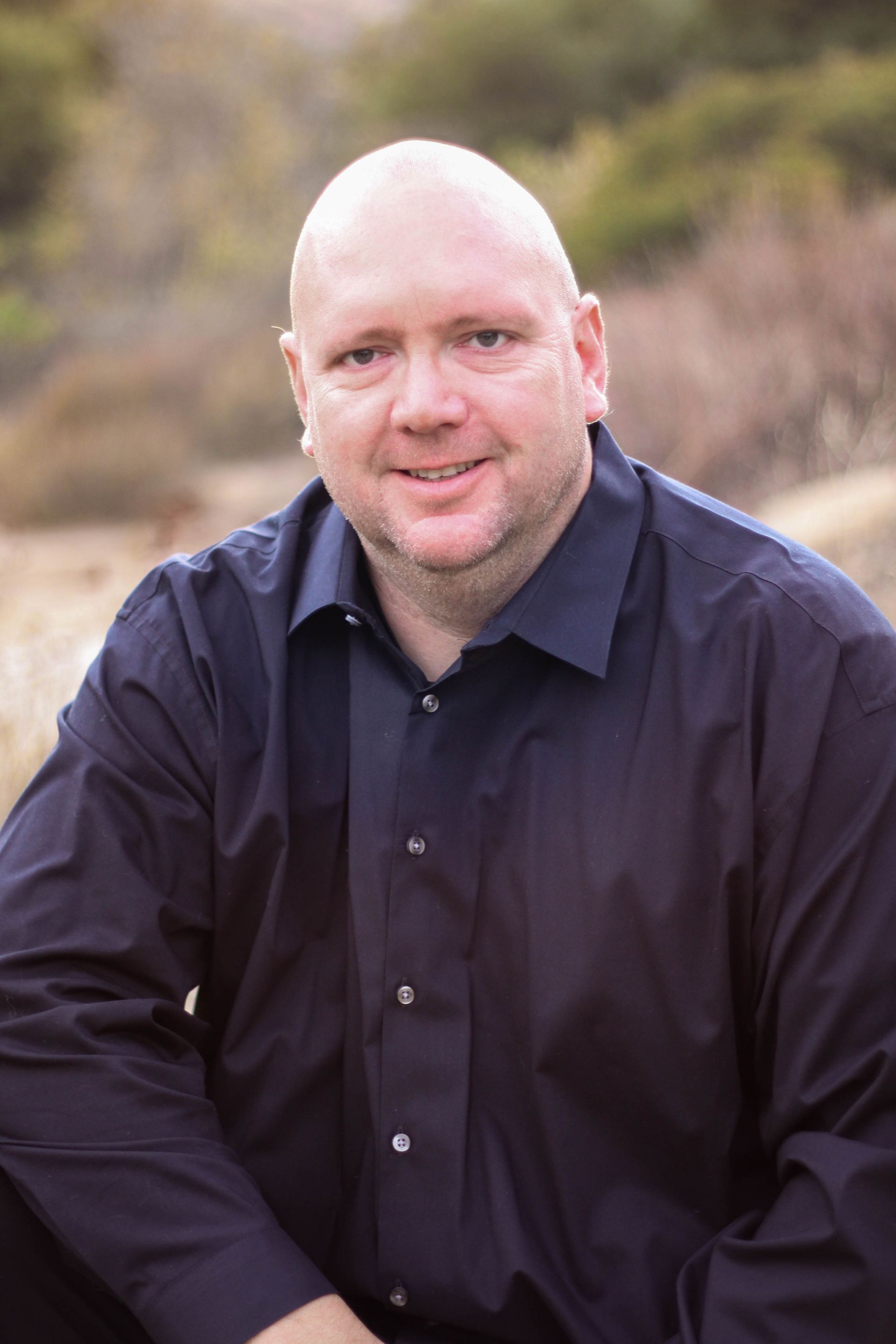 Hammer held in a clenched fist bursting through a star-shaped sign. Black and white.