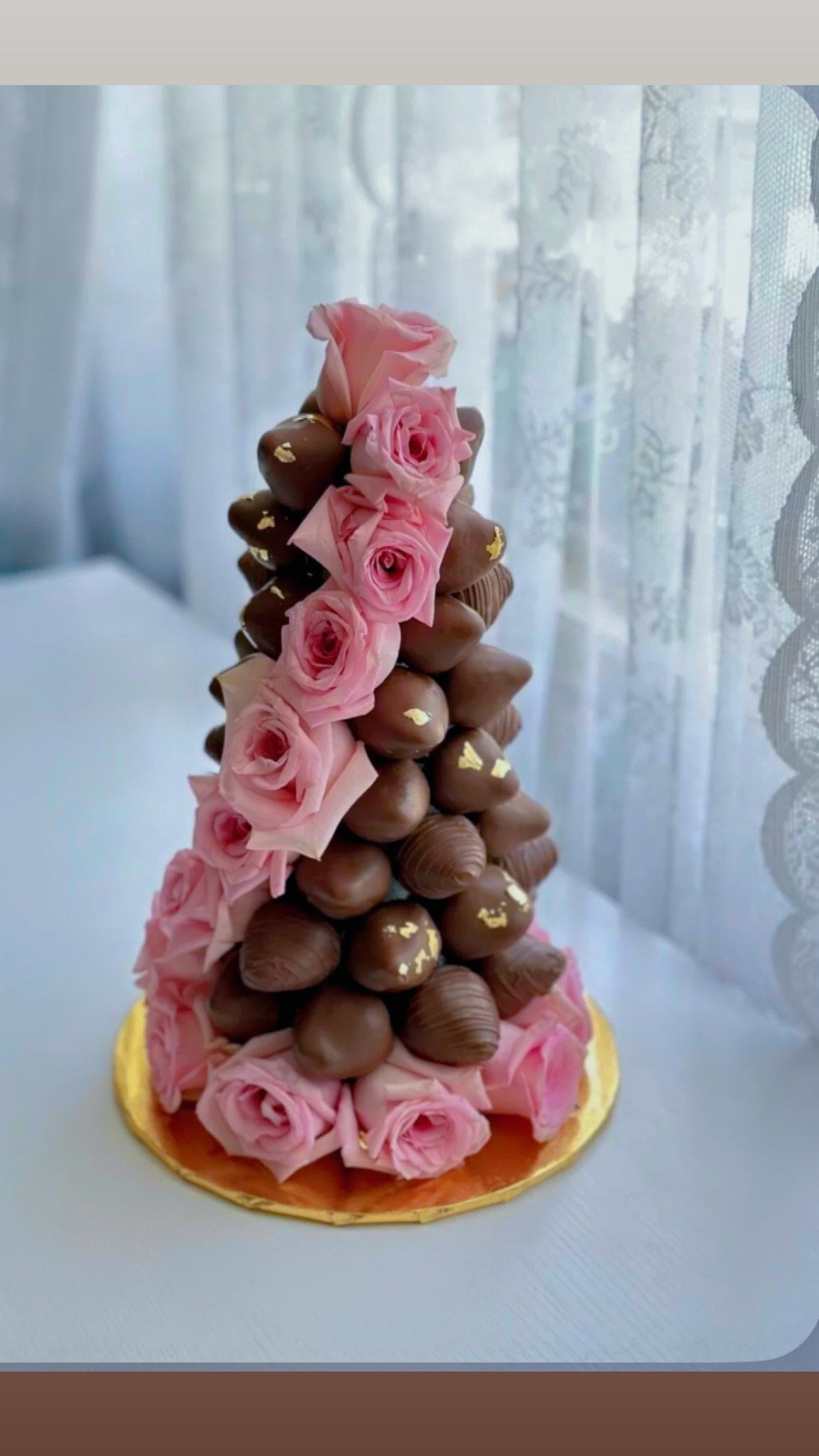 Boxes of Indian sweets, likely ladoo, with a deity figure in the background. Red boxes and almonds are visible.