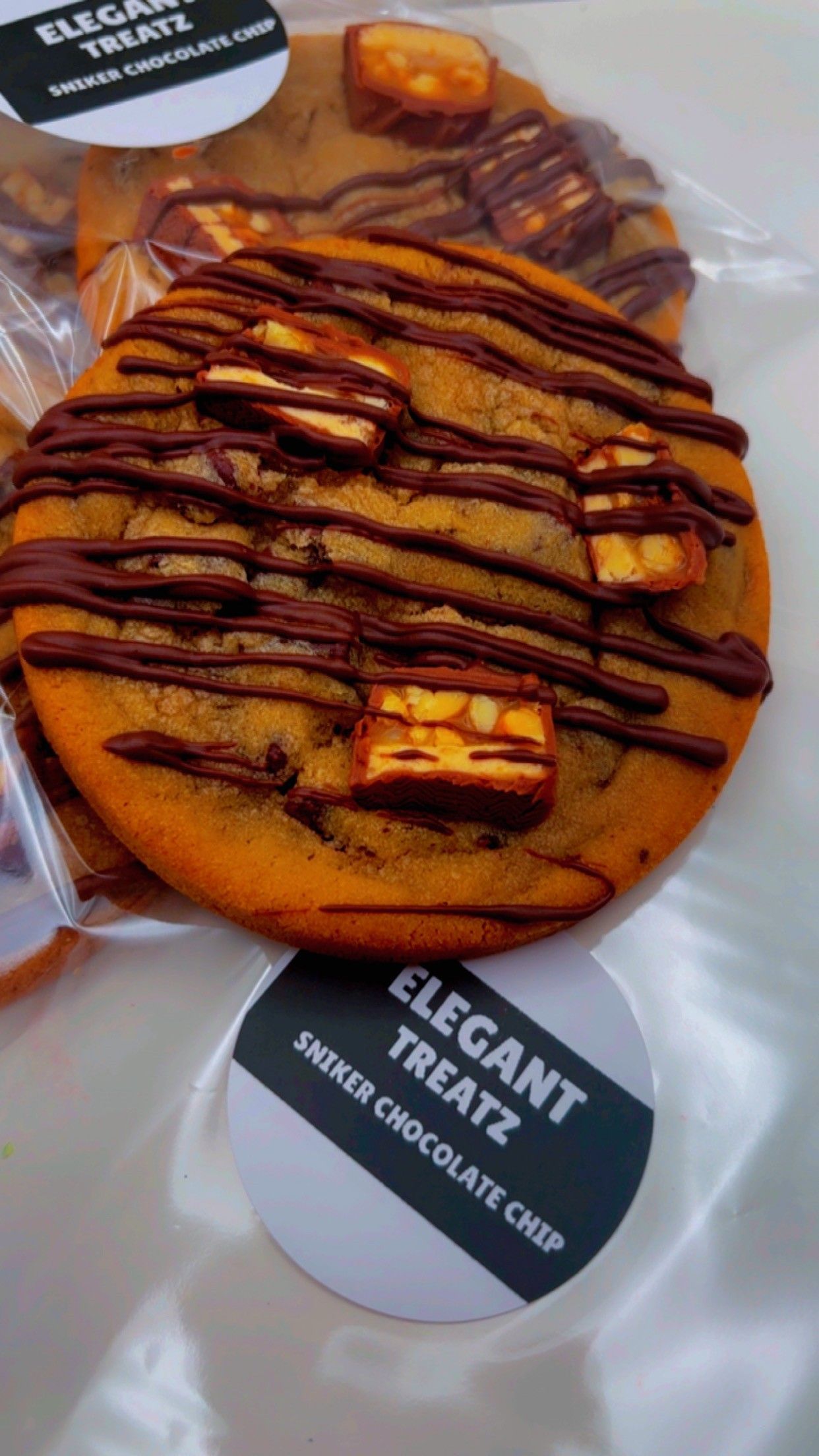 Three-tiered dessert stand with pastries and fruit, teapot, teacup, and pitcher on a marble surface.