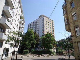 Ein Gebäude mit vielen Fenstern ist von anderen Gebäuden umgeben