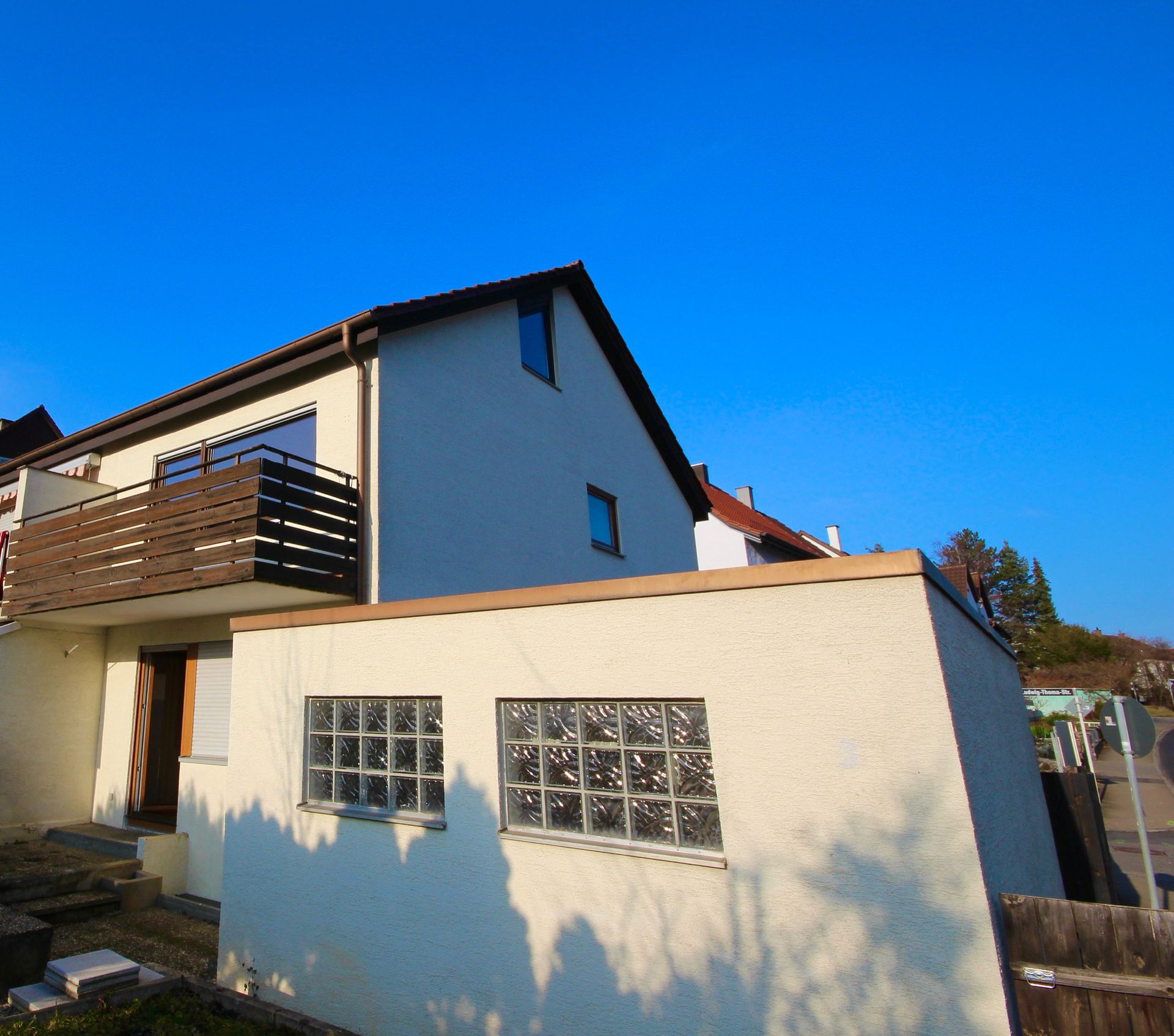 Ein weißes Haus mit Balkon und blauem Himmel im Hintergrund