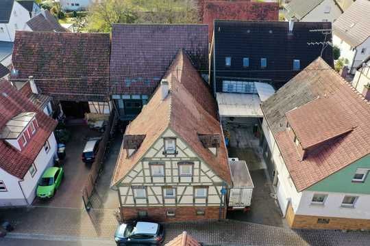 Eine Luftaufnahme einer Häuserreihe mit davor geparkten Autos.