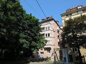 Ein Gebäude mit vielen Fenstern und Bäumen davor.