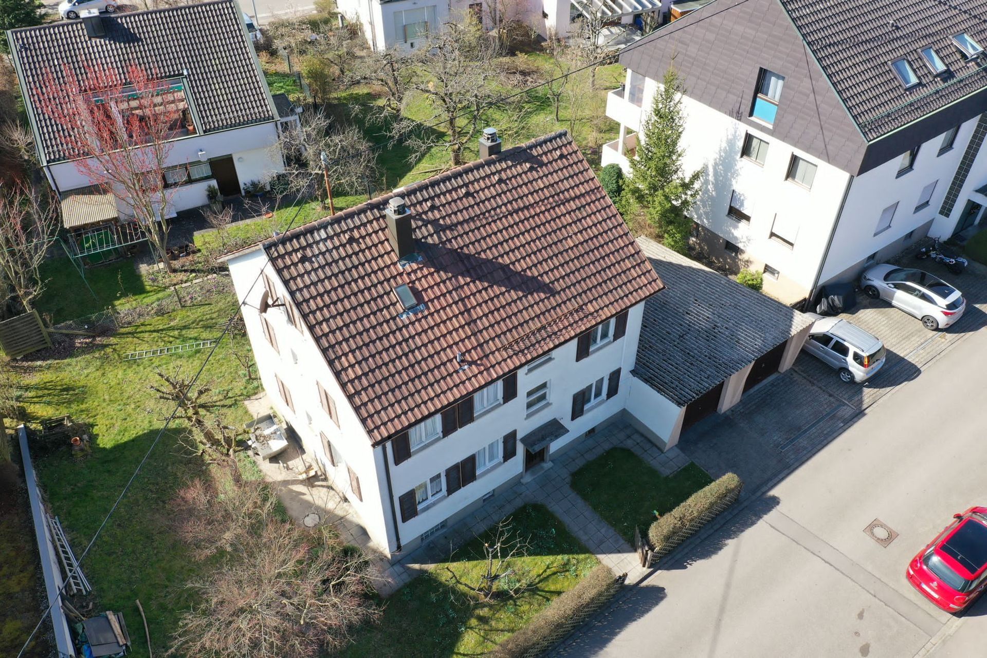 Eine Luftaufnahme eines Hauses mit einem davor geparkten roten Auto