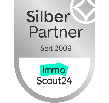 Silbernes Partnerabzeichen mit ImmoScout24-Logo, Schriftzug „Seit 2009“, graues und türkisfarbenes Design