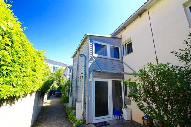 Ein weißes Haus mit einer blauen Markise über der Tür