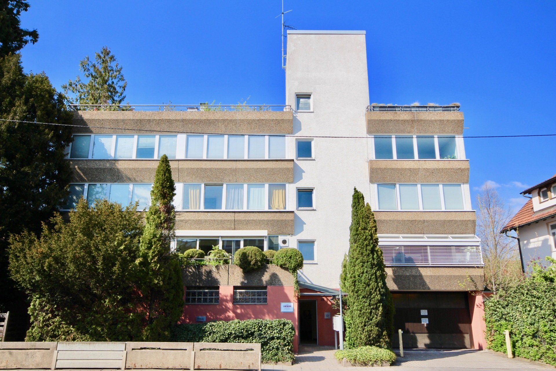 Ein großes Gebäude mit vielen Fenstern und Bäumen davor