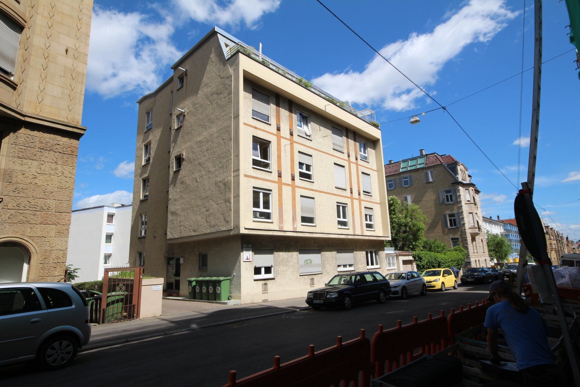 Ein Gebäude mit vielen Fenstern und davor geparkten Autos