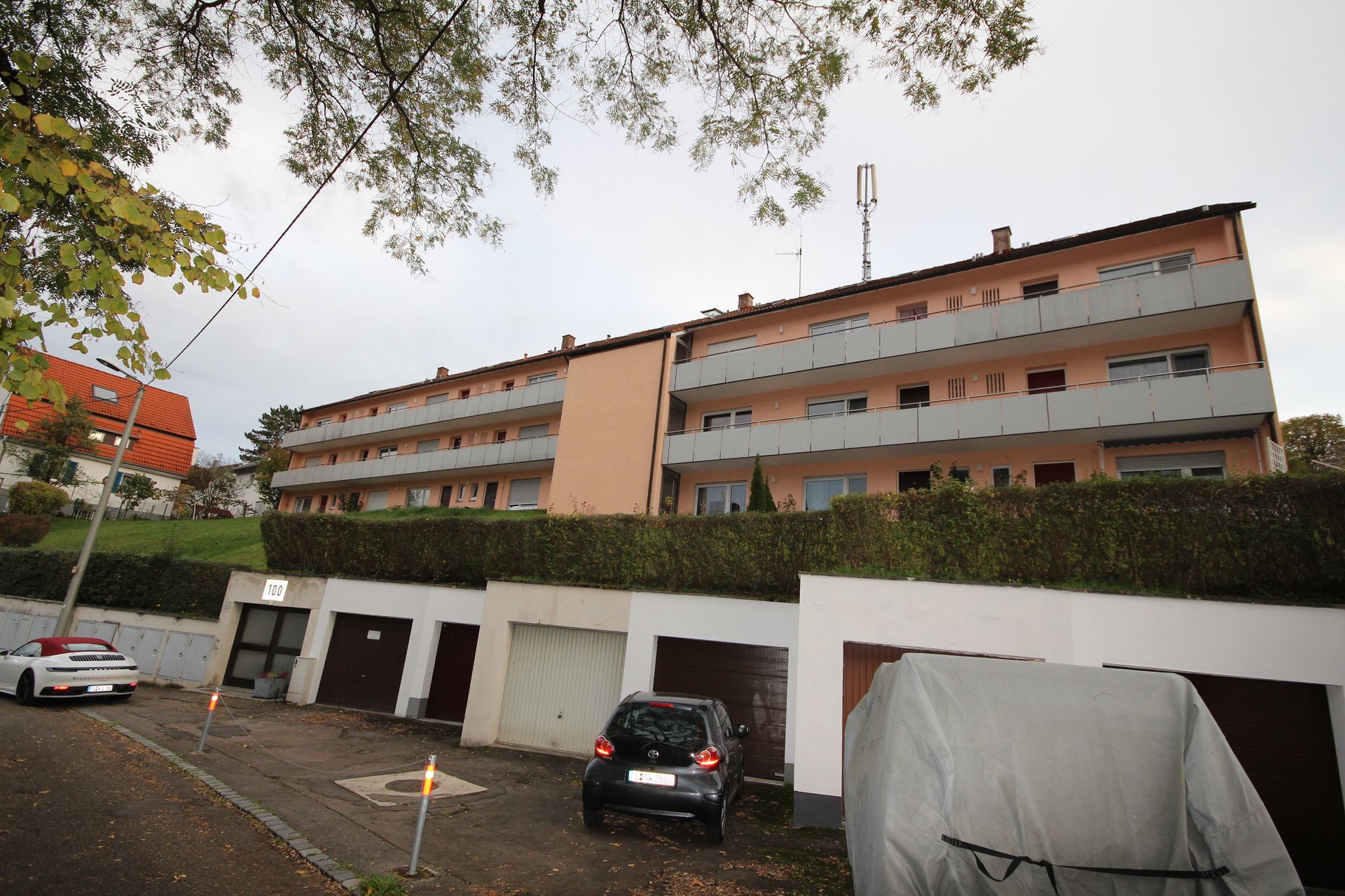 Ein Auto steht vor einem großen Wohnhaus