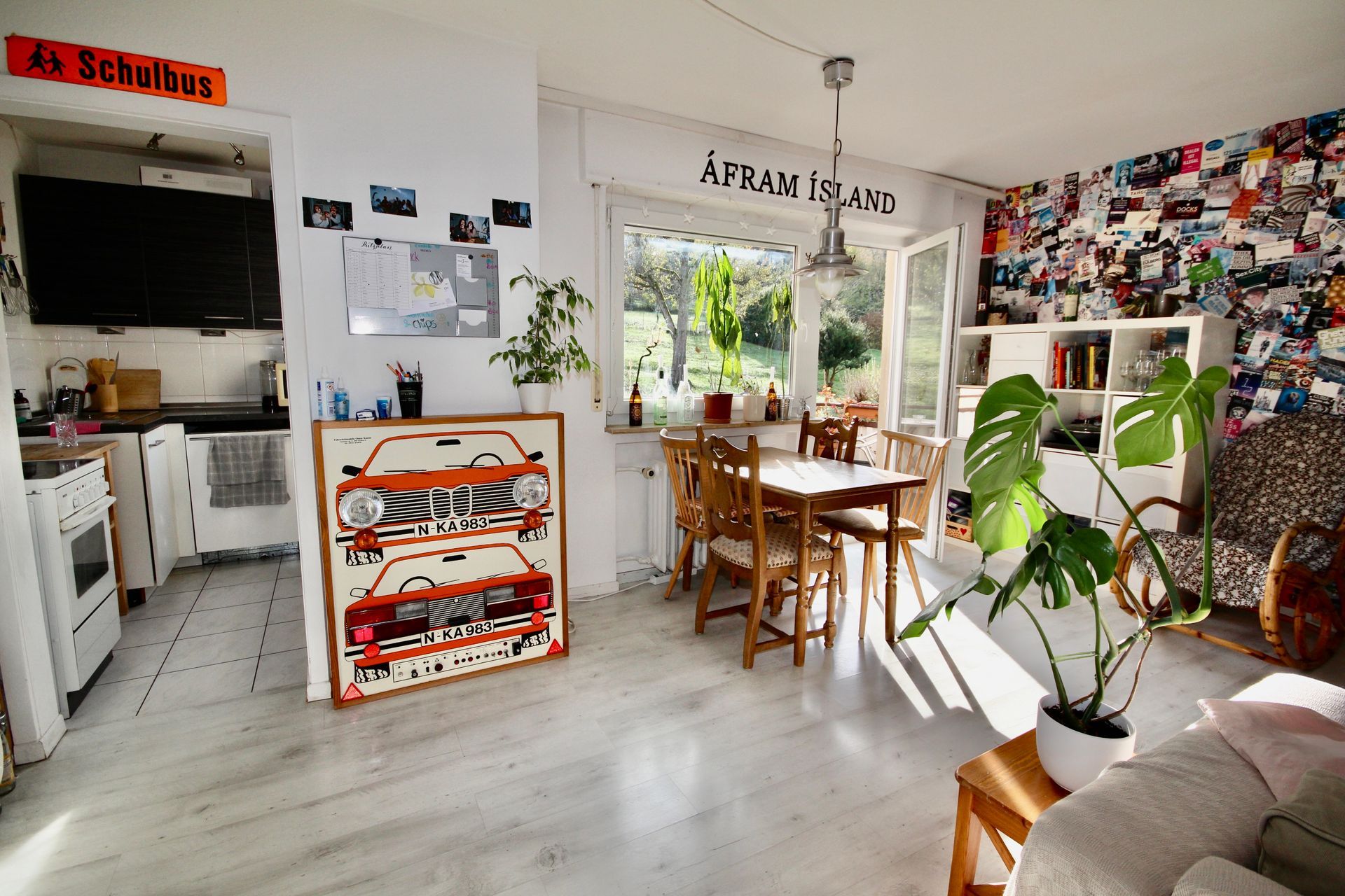 Ein Wohnzimmer mit einem Tisch und Stühlen und einem Auto an der Wand