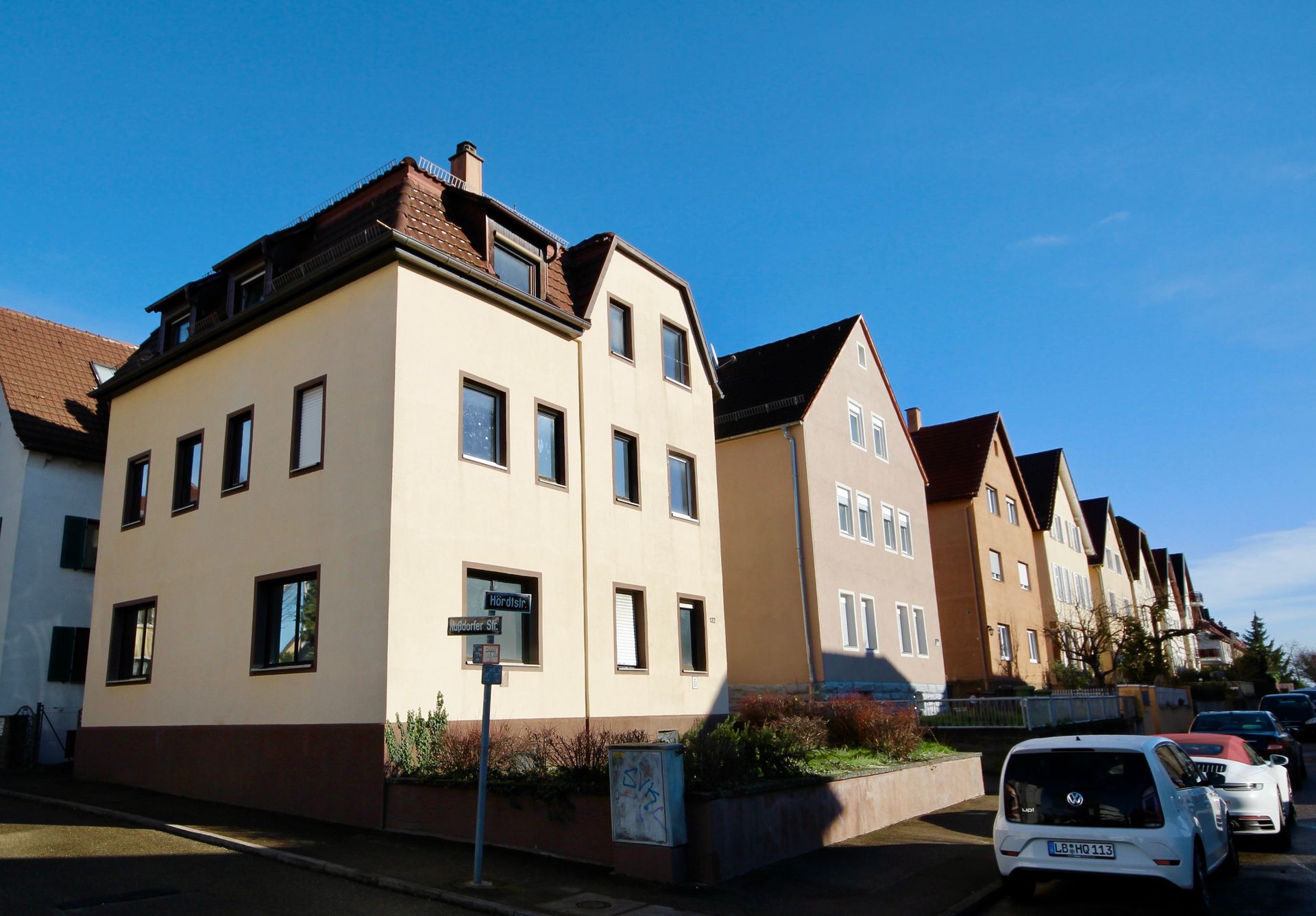 Eine Reihe von Gebäuden mit davor geparkten Autos