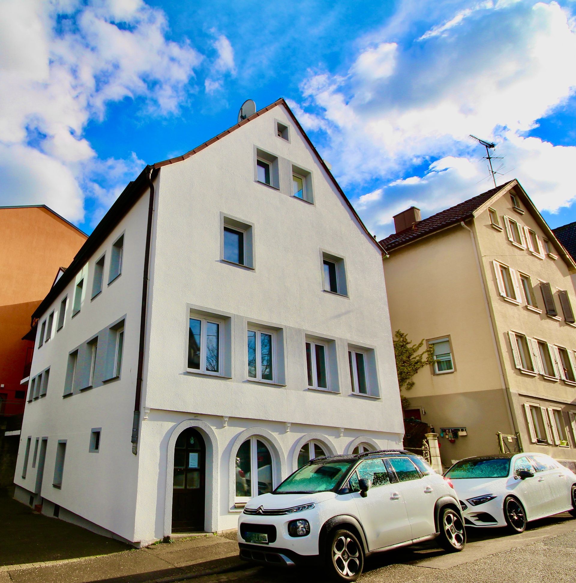 Ein weißes Gebäude mit davor geparkten Autos