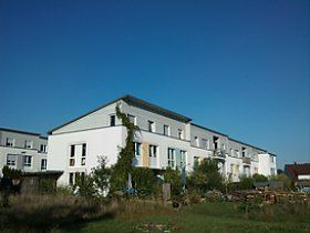 Ein großes weißes Gebäude mit einem blauen Himmel im Hintergrund.