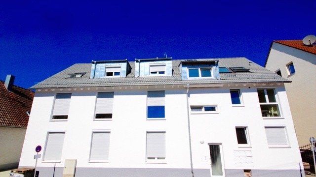 Ein weißes Gebäude mit einem blauen Himmel im Hintergrund